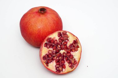 Beyaz arka planda olgun nar kesme meyve yakın