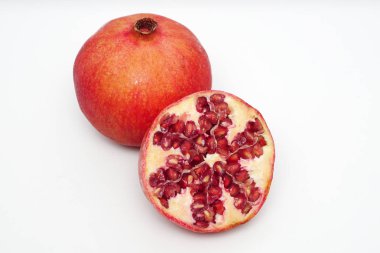 Beyaz arka planda olgun nar kesme meyve yakın