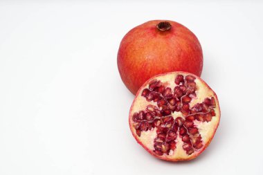 Beyaz arka planda olgun nar kesme meyve yakın