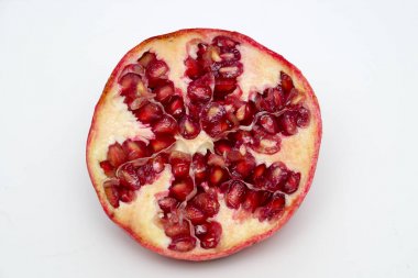 Beyaz arka planda olgun nar kesme meyve yakın