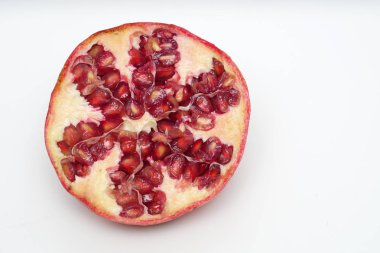 Beyaz arka planda olgun nar kesme meyve yakın