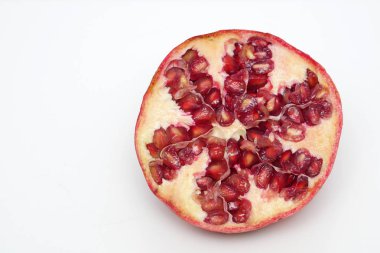 Beyaz arka planda olgun nar kesme meyve yakın
