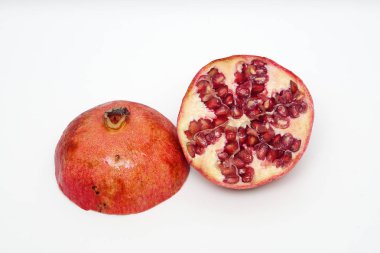 Beyaz arka planda olgun nar kesme meyve yakın
