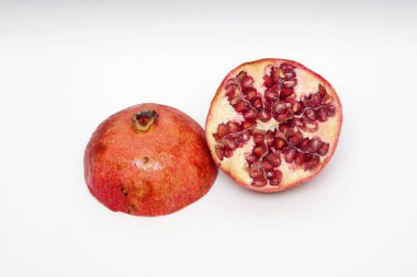 Beyaz arka planda olgun nar kesme meyve yakın