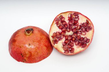 Beyaz arka planda olgun nar kesme meyve yakın