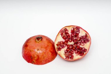 Beyaz arka planda olgun nar kesme meyve yakın