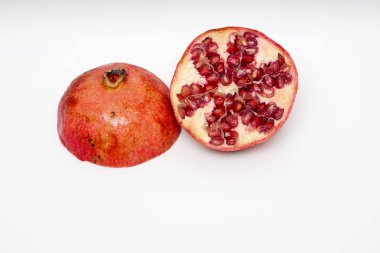 Beyaz arka planda olgun nar kesme meyve yakın