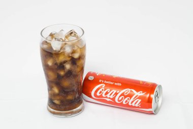 Kırmızı koka kola kutu ve beyaz arka plan üzerinde izole buz küpleri ile cam 
