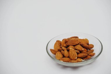 Beyaz arka plan üzerinde cam plaka badem fındık yığını 