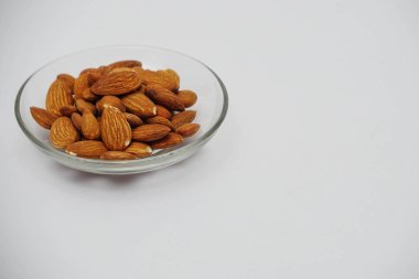 Beyaz arka plan üzerinde cam plaka badem fındık yığını 