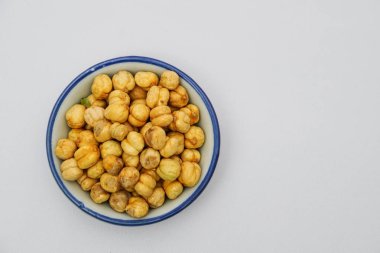 Beyaz arka planda beyaz kase fındık yığını 