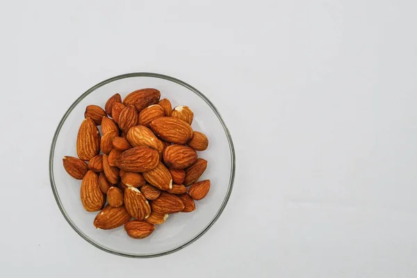 Heap Almond Nuts Glass Plate White Background — Stock Photo, Image