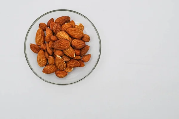 Heap Almond Nuts Glass Plate White Background — Stock Photo, Image