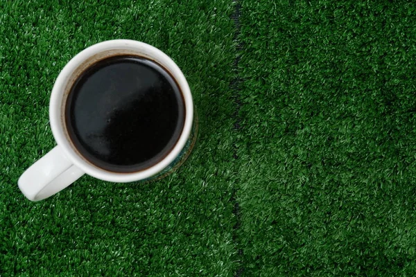 偽の草の背景にブラックコーヒーのカップ — ストック写真