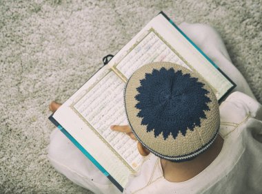Bej halı üzerinde Coran kitap okuma çocuk üst görünümü 