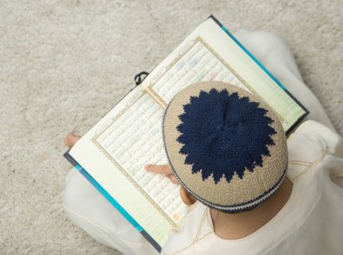 Bej halı üzerinde Coran kitap okuma çocuk üst görünümü 