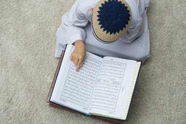 Bej halı üzerinde Coran kitap okuma çocuk üst görünümü 
