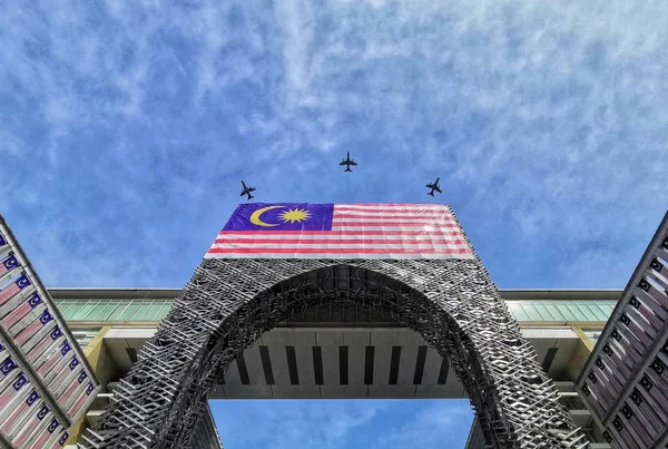 Putrajaya, Malezya bayrağı ve mavi gökyüzünde uçaklar ile metal asansör yapısı kemer düşük açı görünümü 
