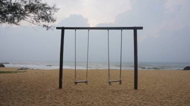 Güneş ışığına karşı tropikal plajda salıncak. 