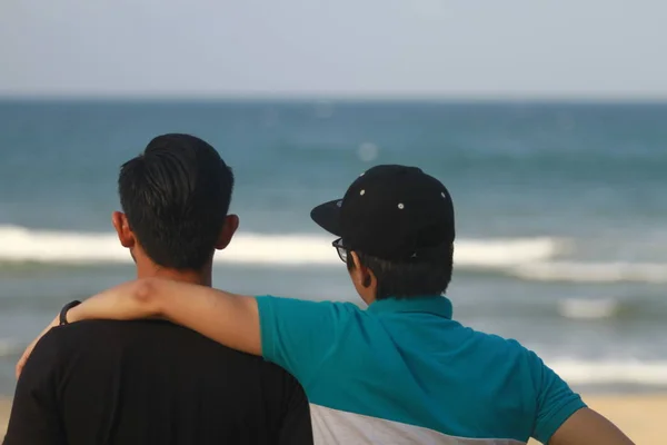 two men standing near ocean