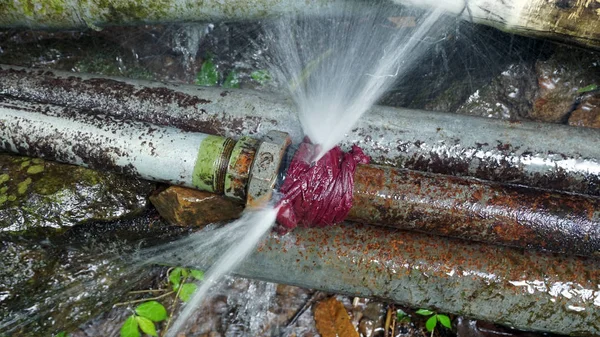 Water burst from a jointer of 2 inch rustic steel pipe