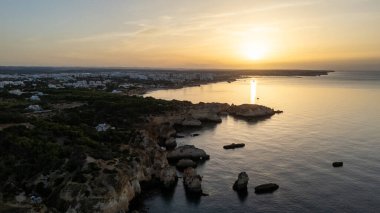 Suyun içinde pürüzlü kayalar olan güzel bir saklanma yeri. Portekiz 'in Algarve bölgesindeki Praia dos Tres Irmaos. Yüksek kalite fotoğraf
