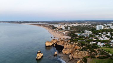 Suyun içinde pürüzlü kayalar olan güzel bir saklanma yeri. Portekiz 'in Algarve bölgesindeki Praia dos Tres Irmaos. Yüksek kalite fotoğraf