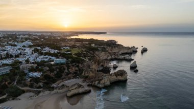 Suyun içinde pürüzlü kayalar olan güzel bir saklanma yeri. Portekiz 'in Algarve bölgesindeki Praia dos Tres Irmaos. Yüksek kalite fotoğraf