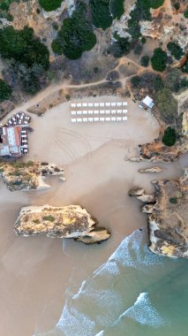 Suyun içinde pürüzlü kayalar olan güzel bir saklanma yeri. Portekiz 'in Algarve bölgesindeki Praia dos Tres Irmaos. Yüksek kalite fotoğraf