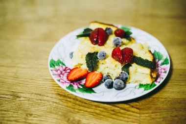Ahşap bir masada çilek ile elmalı turta bir parça