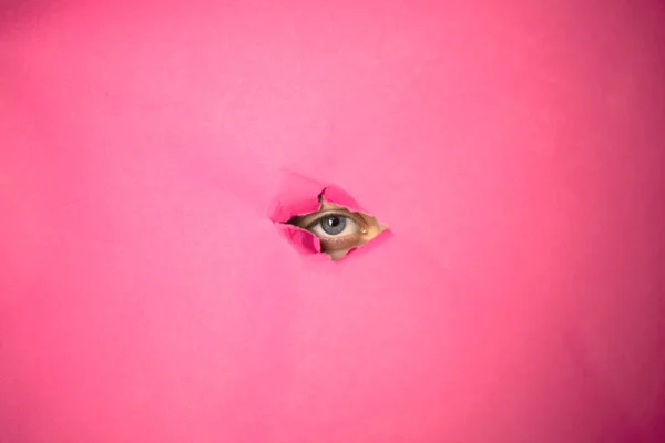 Olho Olha Através Buraco Papel Rosa — Fotografia de Stock