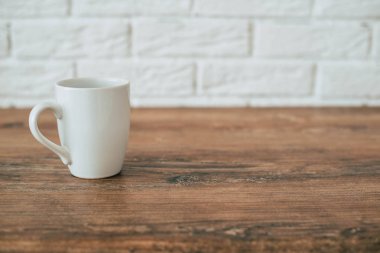 ahşap bir masa üzerinde beyaz fincan