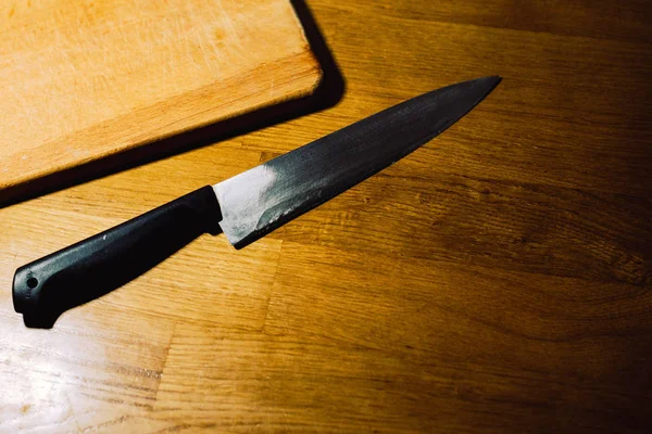 Knife and a wooden board on the table