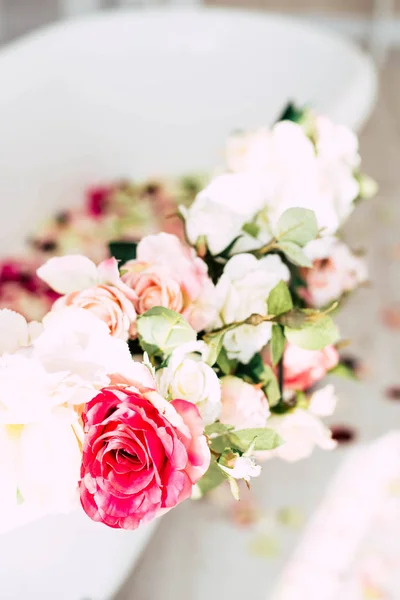 White classical bath with flowers and petals of roses