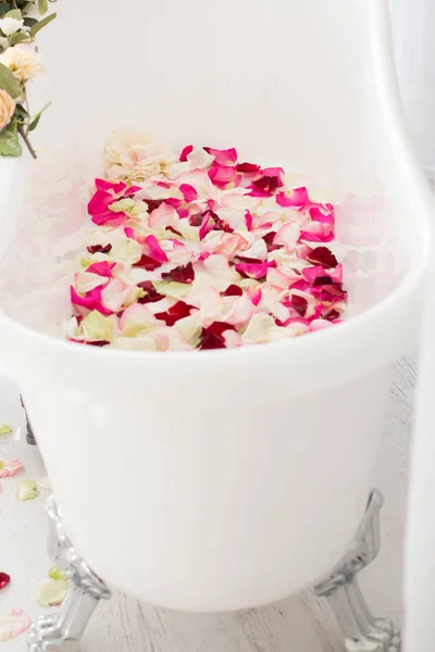 White classical bath with flowers and petals of roses