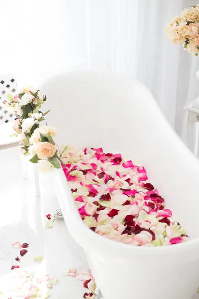 White classical bath with flowers and petals of roses