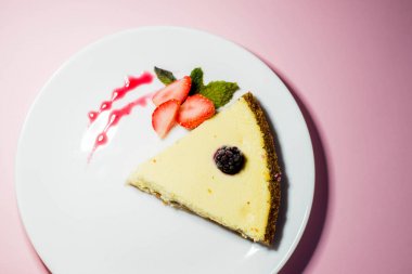 peynirli kek çilek beyaz tabakta ile