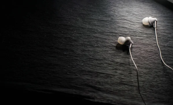 White headphones on black background