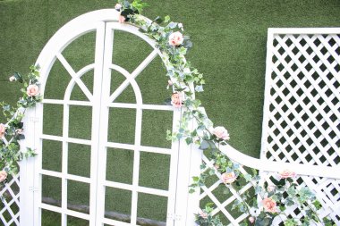 Çiçeklerle süslenmiş beyaz düğün kemeri.