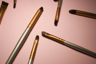 pembe arka planda makyaj fırçaları