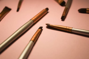pembe arka planda makyaj fırçaları