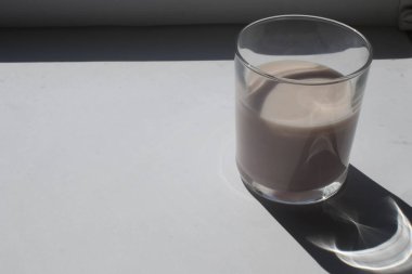 Beyaz arka planda bir bardak yoğurt.