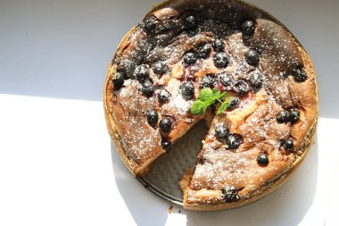 Beyaz arka planda dilimlenmiş peynirli turta.