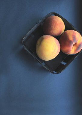 Şeftaliler siyah arka planda sepette