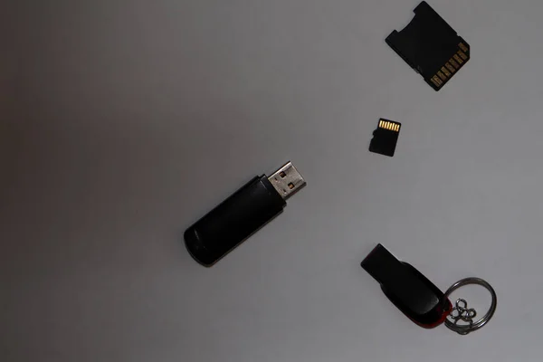 Different black flash drives on a gray background