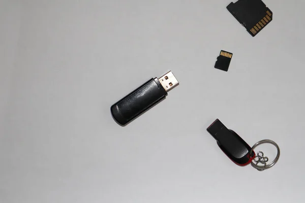 Different black flash drives on a gray background