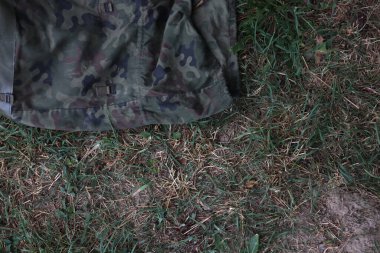 Çimlerin üzerinde eski bir askeri çanta.