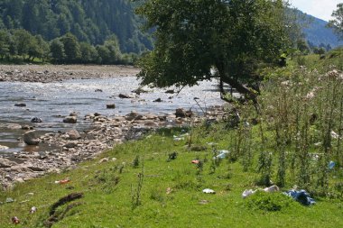 Dağlarda nehir kıyısında çöp