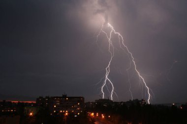 Şehrin üzerinde gece gökyüzünde gök gürültülü sağanak ve şimşek