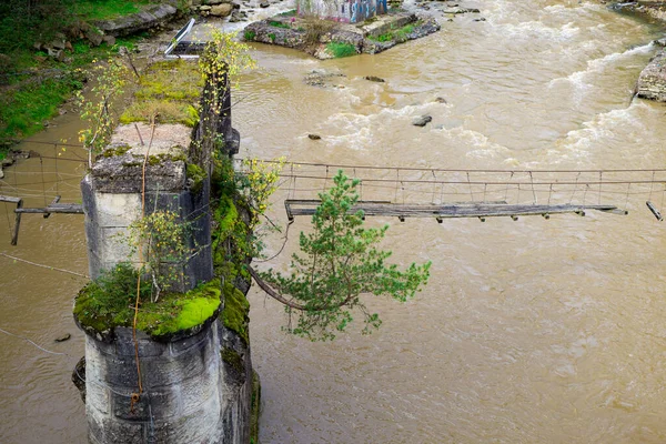 山の川の上に古い壊れた吊橋 — ストック写真